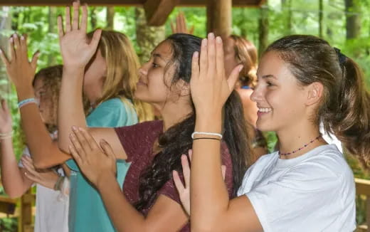 a group of girls with their hands up