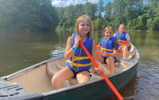 a group of kids in a canoe