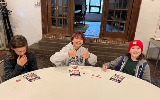a group of girls sitting at a table with cards