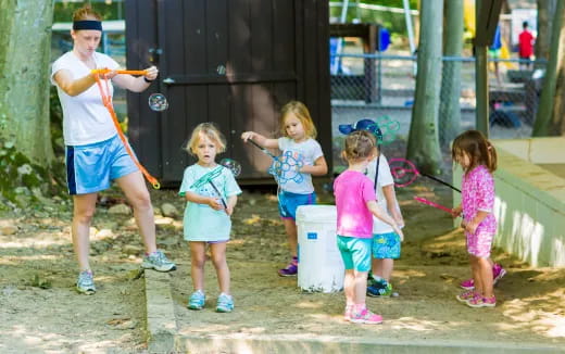 a group of children playing with a man and woman