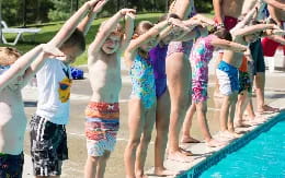 a group of children playing in a pool