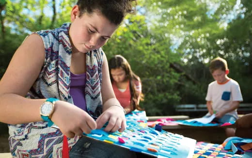 a young boy painting on a table