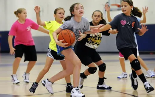 a group of girls playing basketball