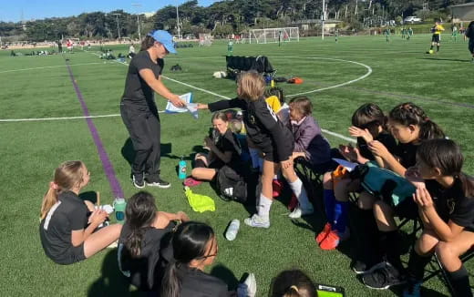 a person talking to a group of people on a field