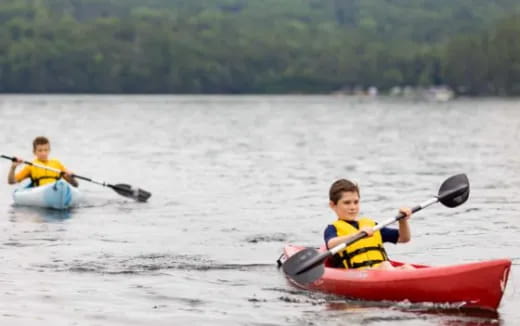 a couple of people in kayaks on a lake