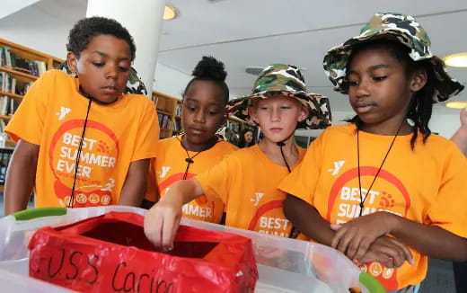 a group of kids in orange shirts