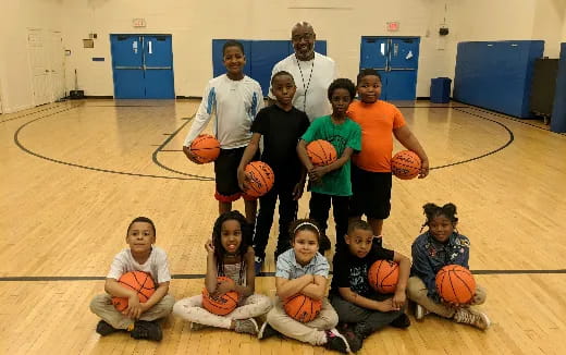 a group of people posing for a photo with basketballs