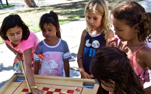 a group of young girls playing a board game