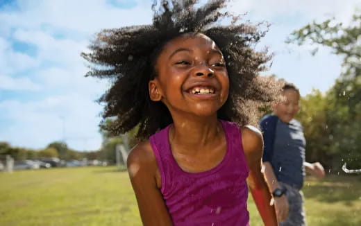 a woman smiling with a man behind her