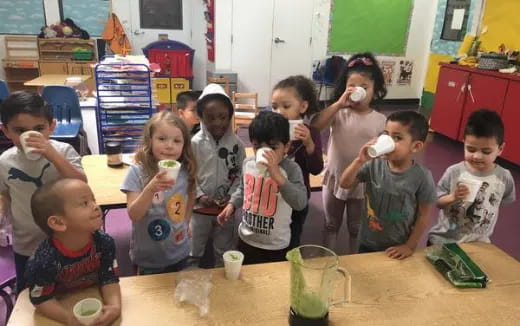 a group of children drinking from cups