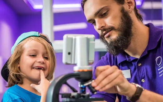 a man and a girl looking at a microscope