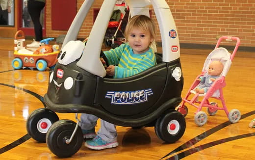 a child in a stroller with a baby in it