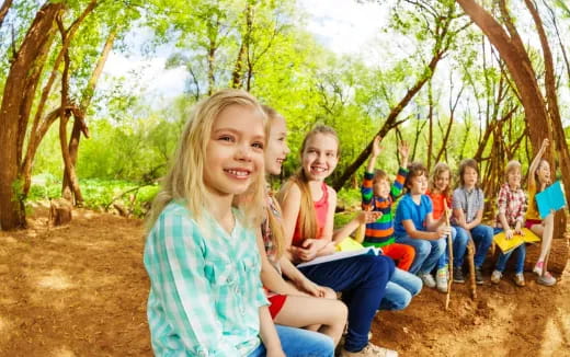 a group of children sitting on a bench in a park