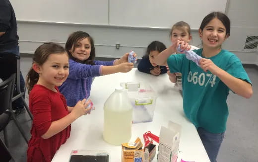 a group of children holding up plastic containers