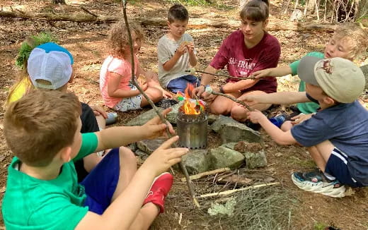 a group of children sitting around a fire