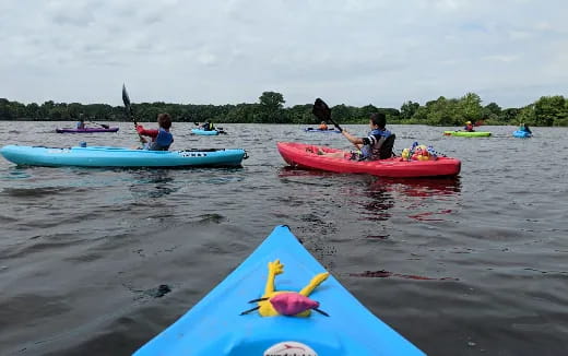 people in kayaks on a lake