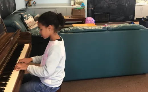 a girl playing a piano