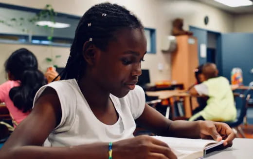 a young girl sitting at a desk