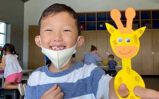 a child holding a yellow toy