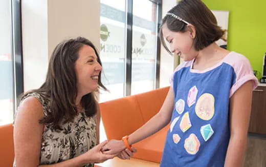 a woman holding a child's hand