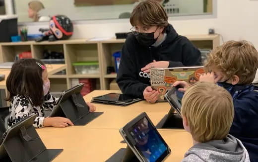 a group of children looking at a tablet