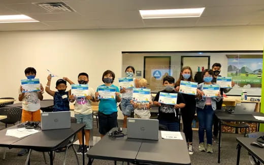a group of children holding laptops