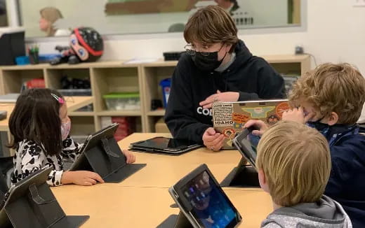 a group of children using laptops
