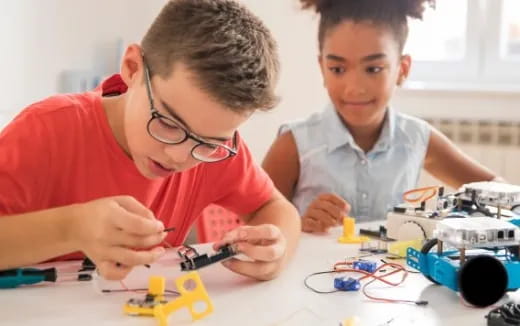a couple of boys looking at a toy