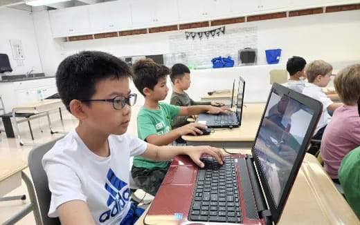 a group of children using laptops