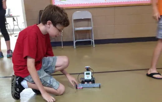 a boy playing with a toy robot