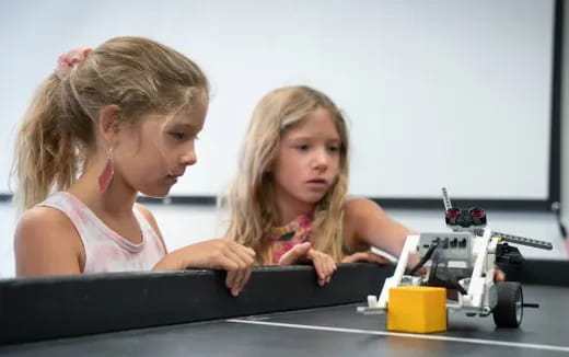a couple of girls looking at a computer