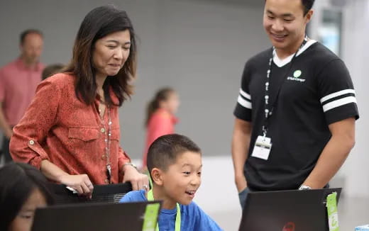 a group of people looking at a laptop