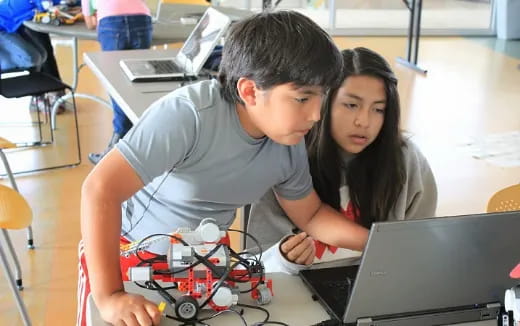 a man and a woman looking at a laptop