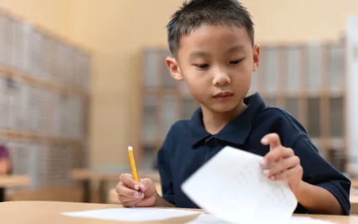 a boy holding a pencil