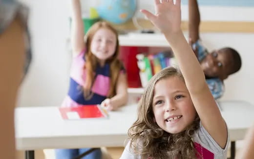 a group of children raising their hands
