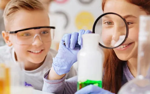 a few young girls wearing lab coats