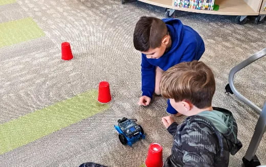 a person and a boy playing with toys on the ground