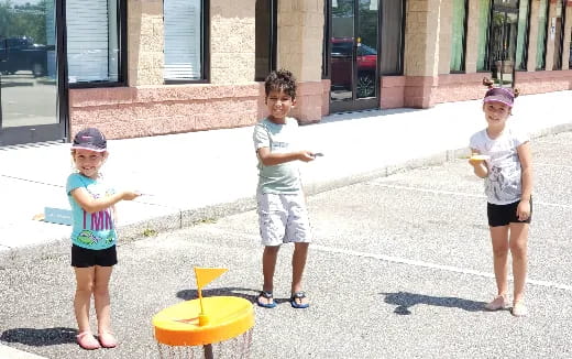 a group of children playing with a yellow toy