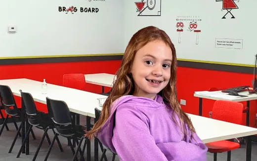 a girl smiling in a classroom