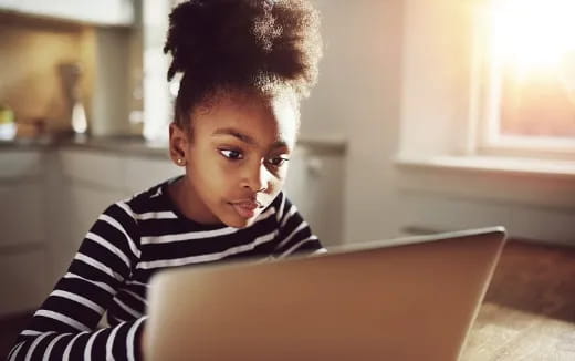 a young boy looking at a laptop
