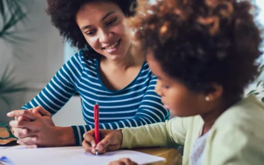 a person and a child writing on a book