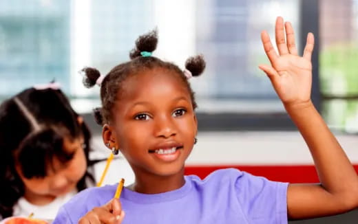 a young girl raising her hand