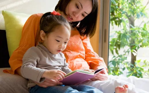 a person and a child looking at a book