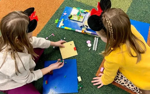 a few young girls playing with a puzzle