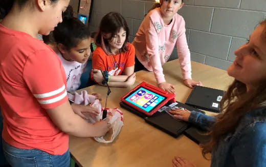 a group of children playing with a tablet