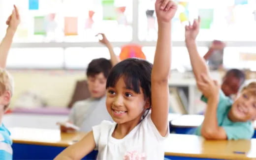 a group of children raising their hands