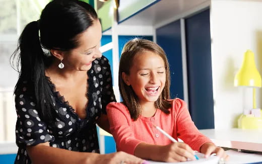 a woman and a girl looking at a paper