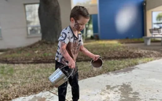 a boy carrying a bottle