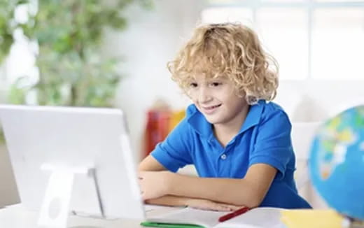 a young boy sitting at a desk