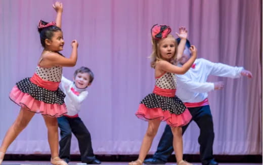 a group of children dancing on a stage